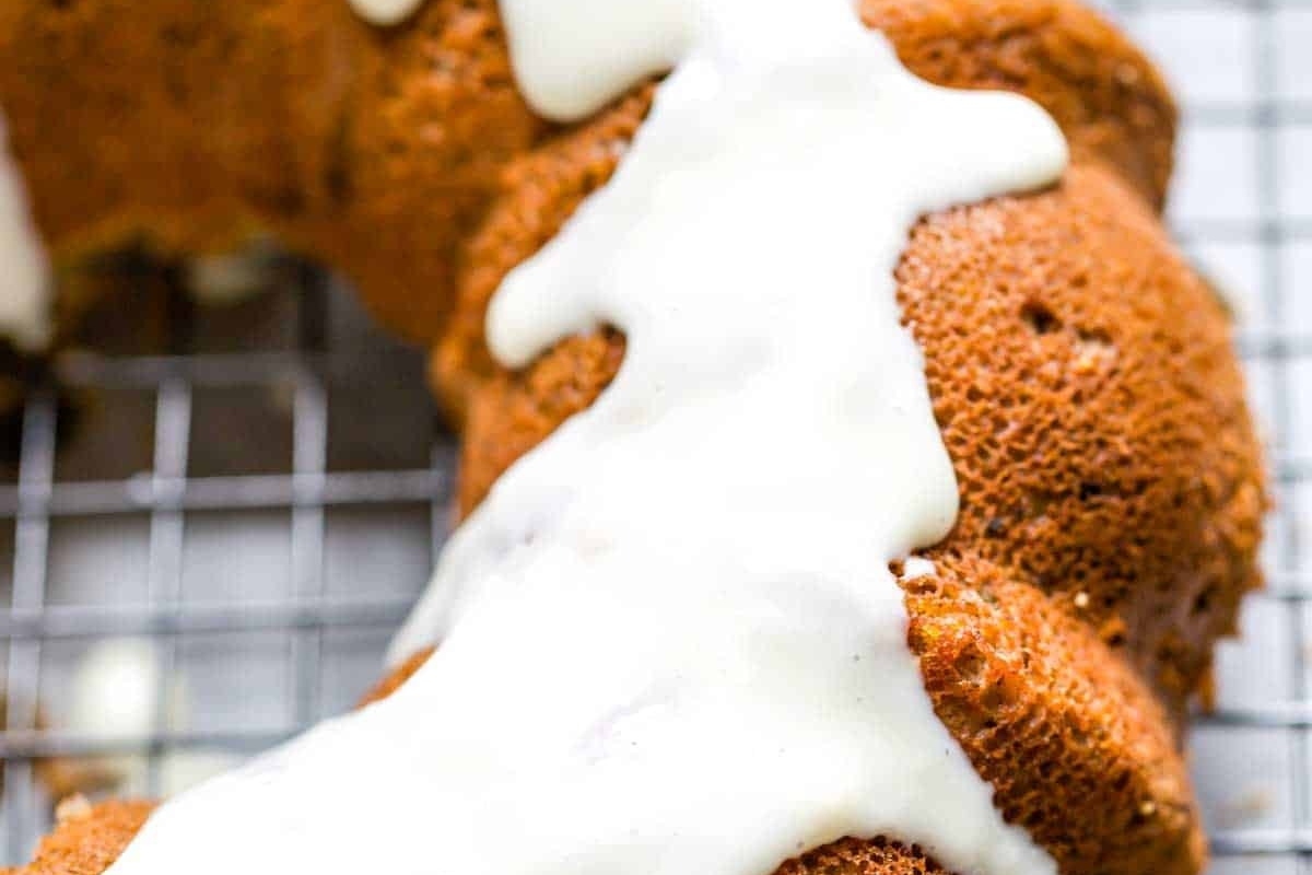 A Bundt cake with icing sitting on a cooling rack.