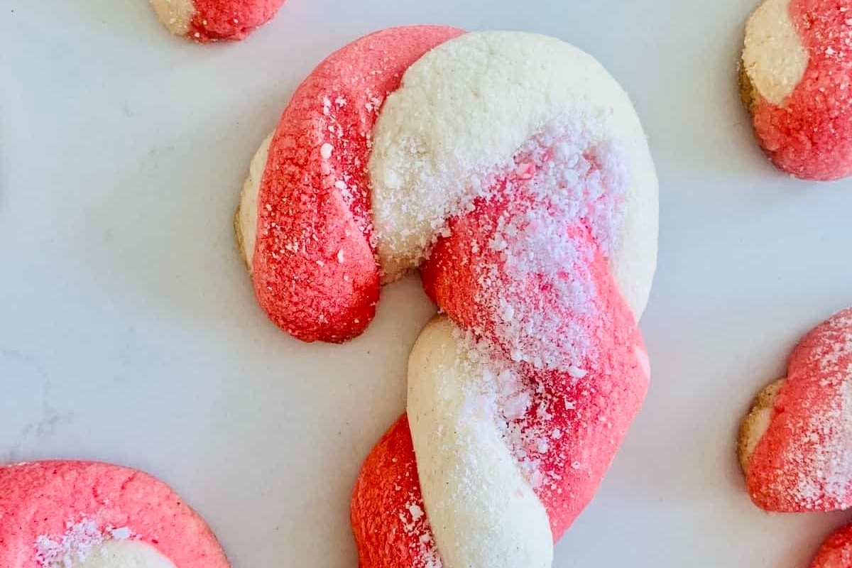 Red and white candy cane cookies on a white surface, perfect for Candy Cane Recipes.