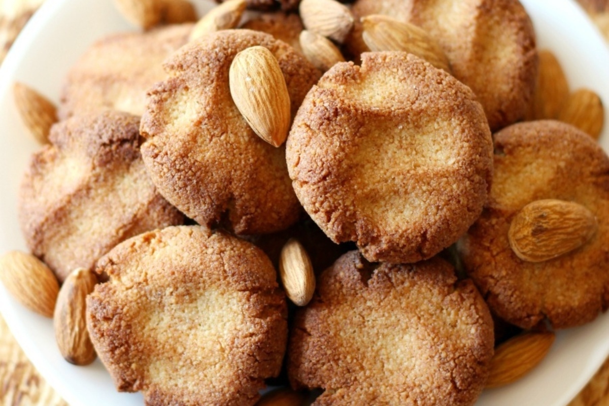 Italian almond cookies on a plate with almonds.