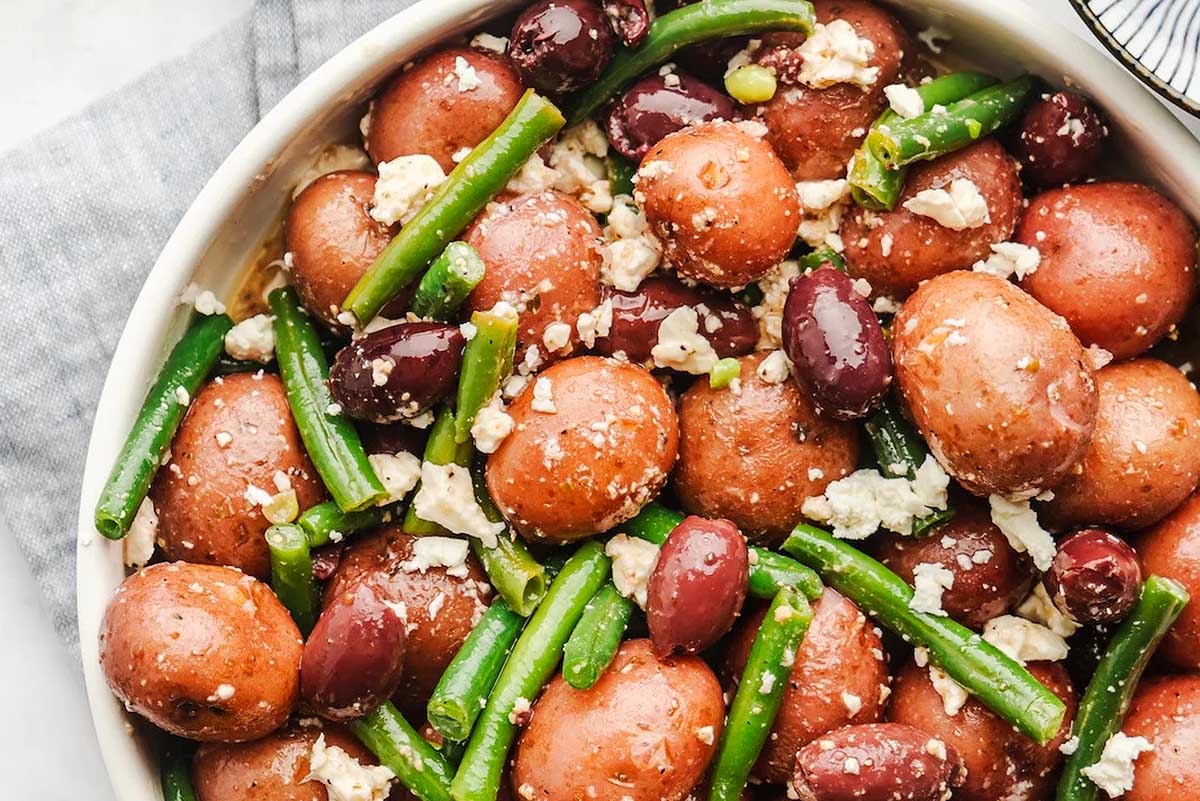 Potatoes and green beans in a white bowl.