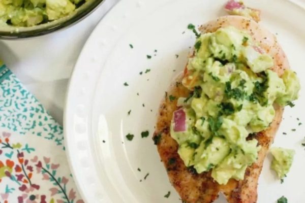 A plate of chicken with guacamole on it.