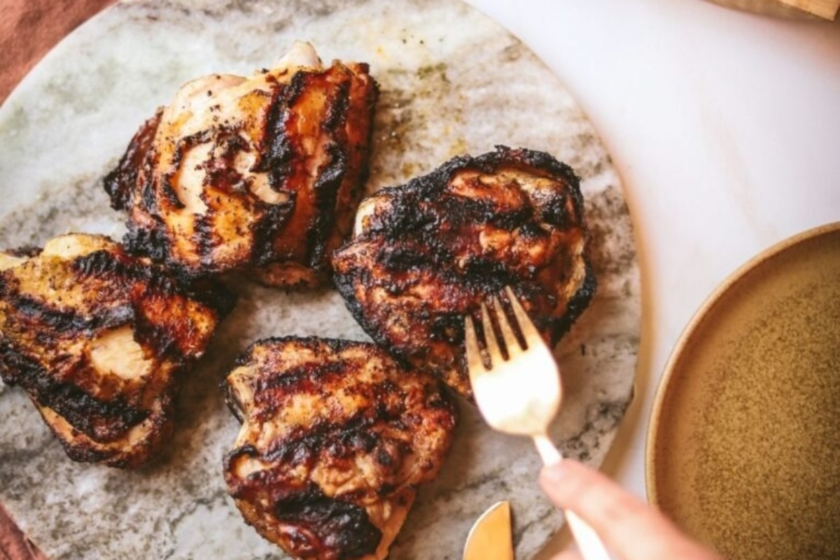 Grilled chicken on a plate with a fork.