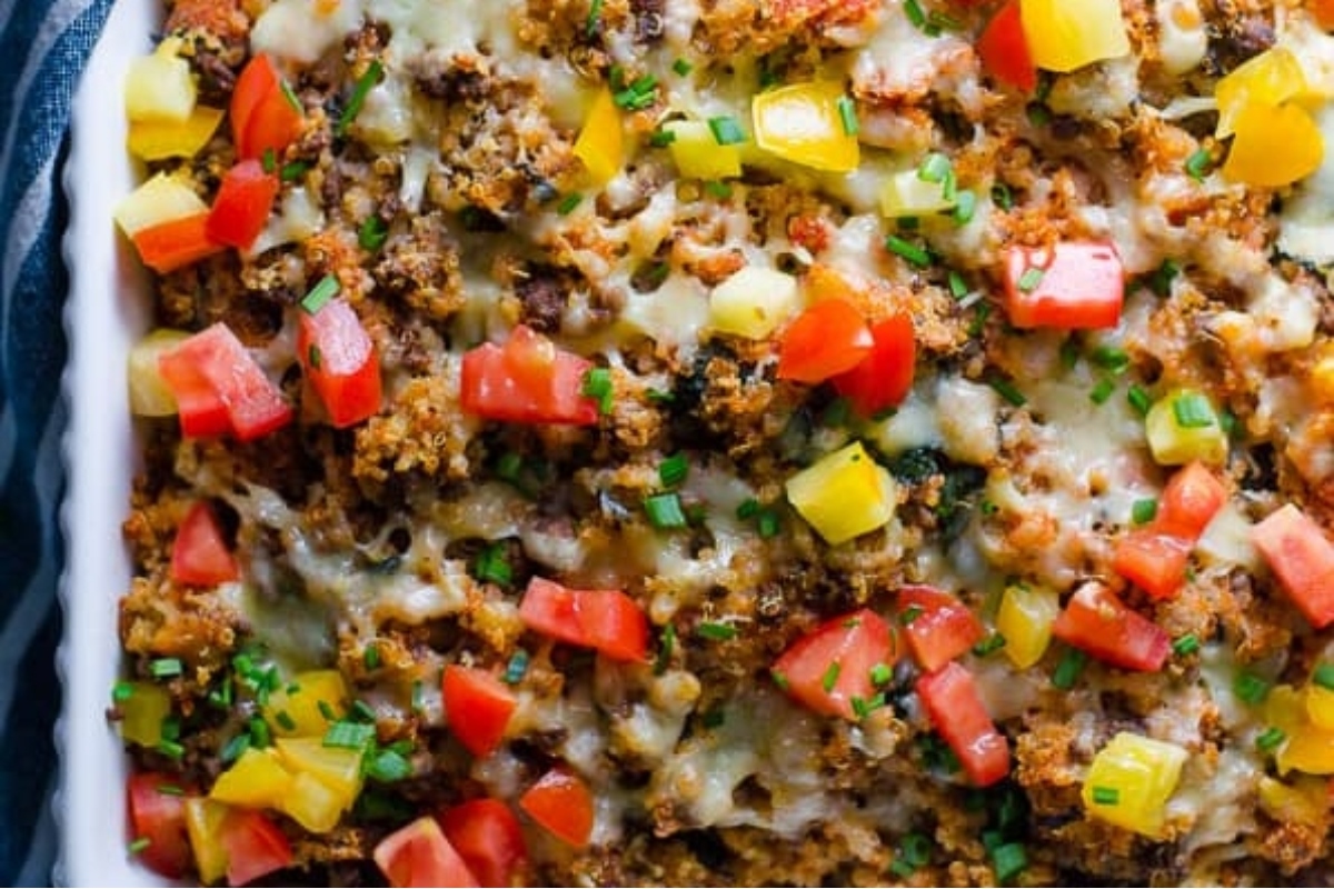 A ground turkey casserole dish topped with vegetables and cheese.