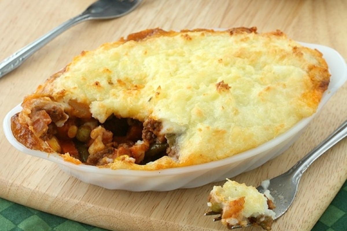 Irish shepherd's pie topped with frozen mixed vegetables in a white dish, ready to be enjoyed with a fork. Discover delicious recipes for this classic dish.