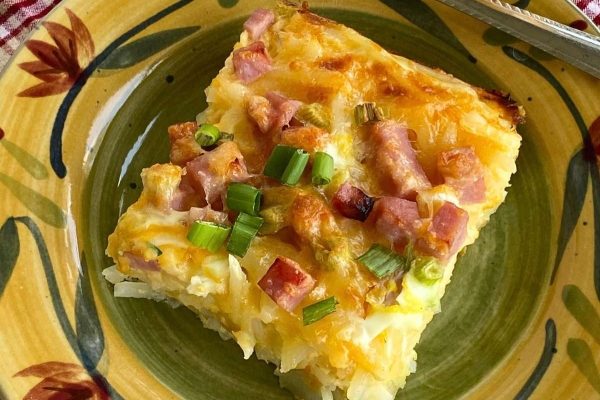 A piece of ham and cheese casserole on a plate.