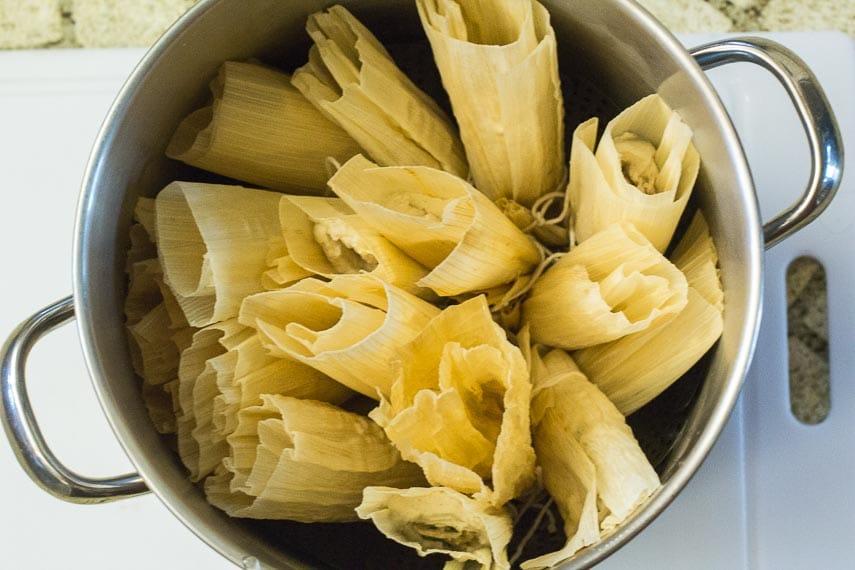 Tamales in a pot on top of a cutting board.