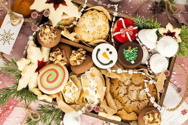 Festive Christmas cookies arranged in a wooden crate, ready for gift giving on a beautifully decorated table.
