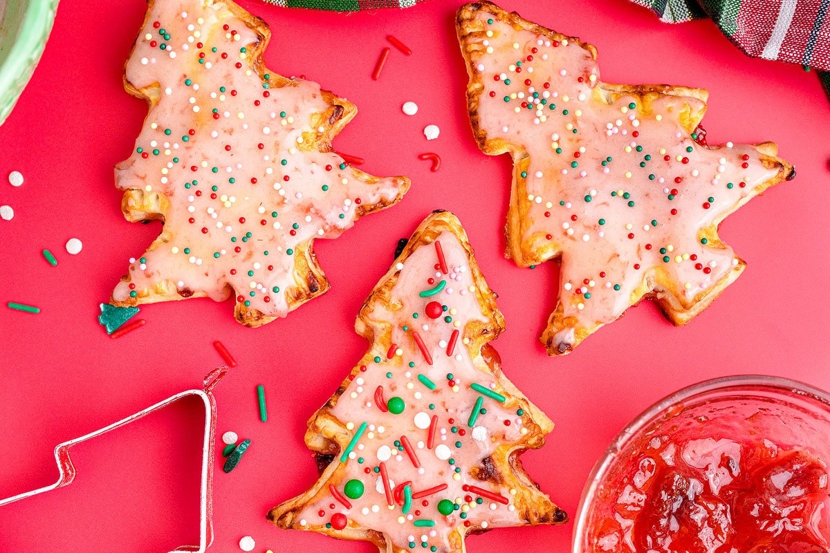 24 Christmas Tree Recipes to Add Magic to the Holidays 7 Traditional Christmas cookies with icing and jam on a red background.