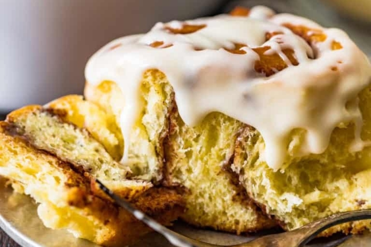 Cinnamon rolls adorned with sweet icing are perfectly arranged on a plate.
