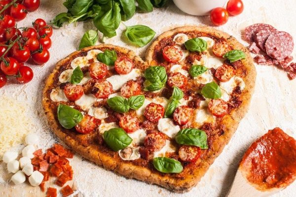 A heart shaped pizza with tomatoes and mozzarella - perfect for Parents Love and Kid Friendly Recipes.