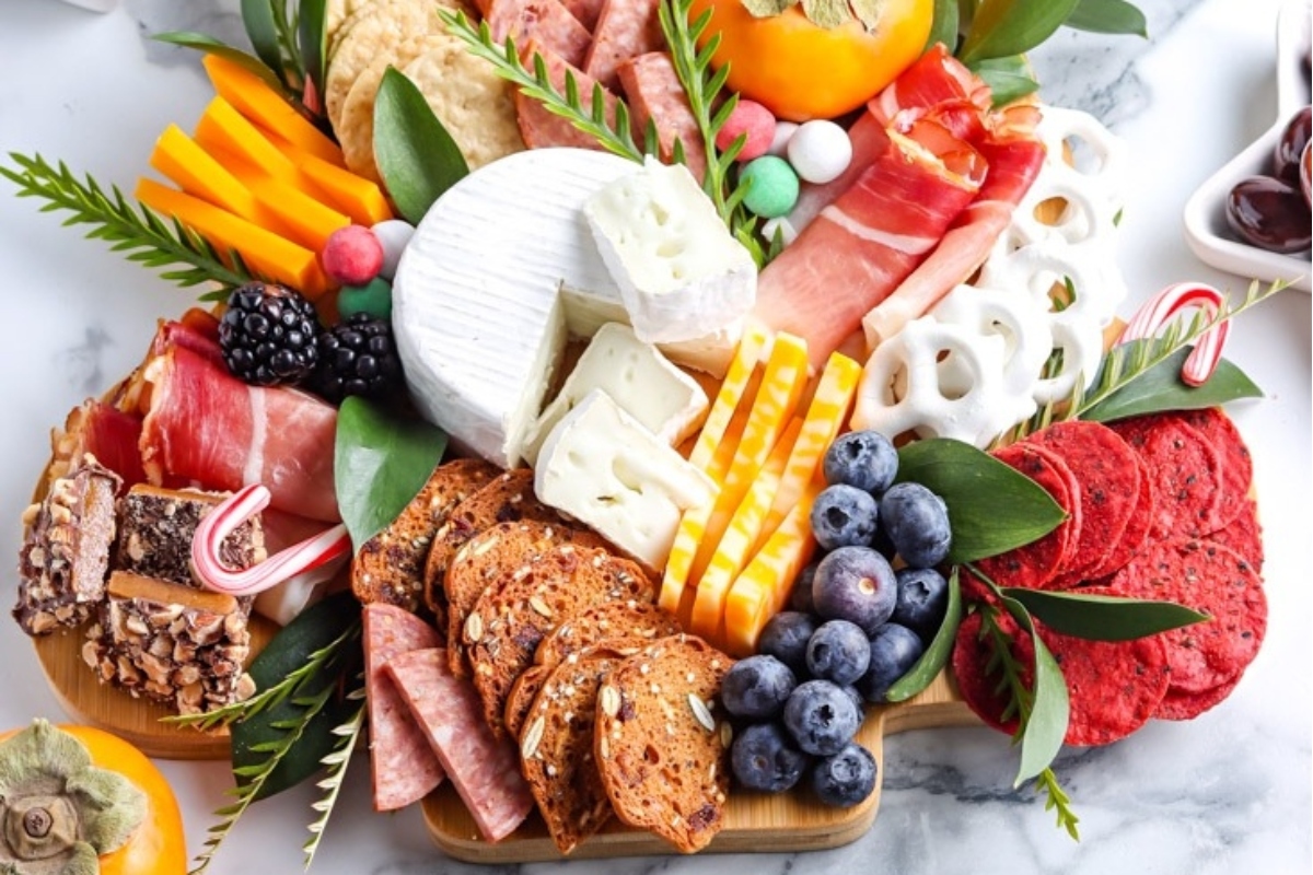 A Christmas charcuterie board filled with an enticing assortment of meats, cheeses, fruits, and nuts.