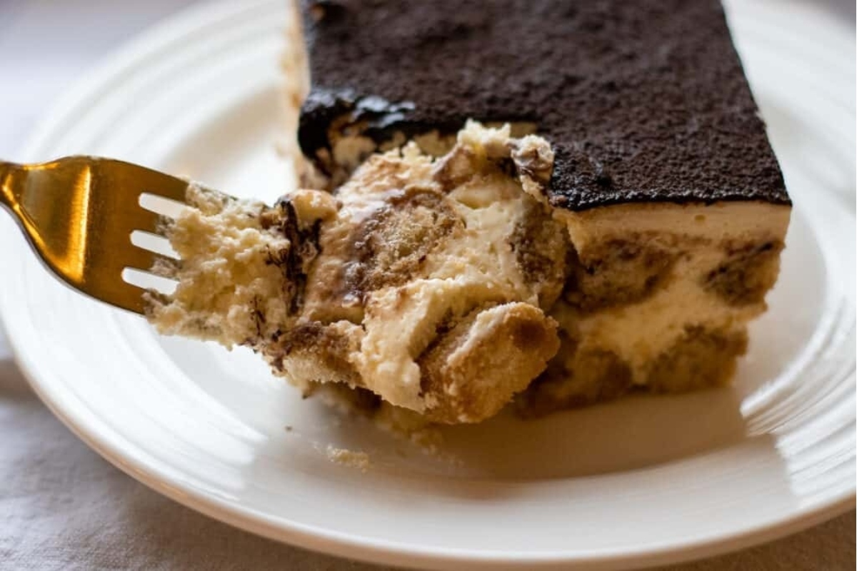 A No-Bake piece of tiramisu on a plate with a fork, perfect for Holiday Desserts.
