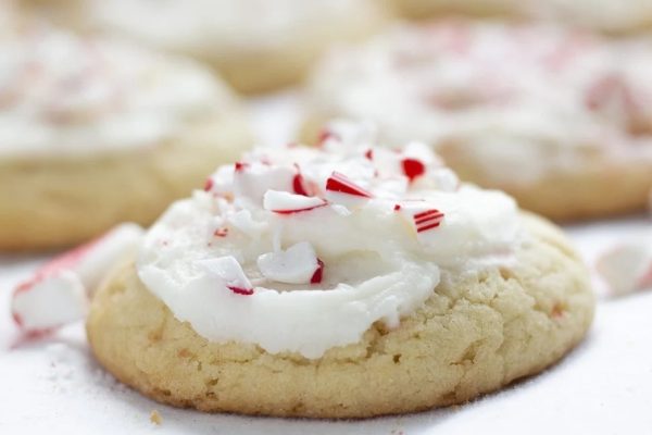A plate of cookies with peppermint icing and candy canes.