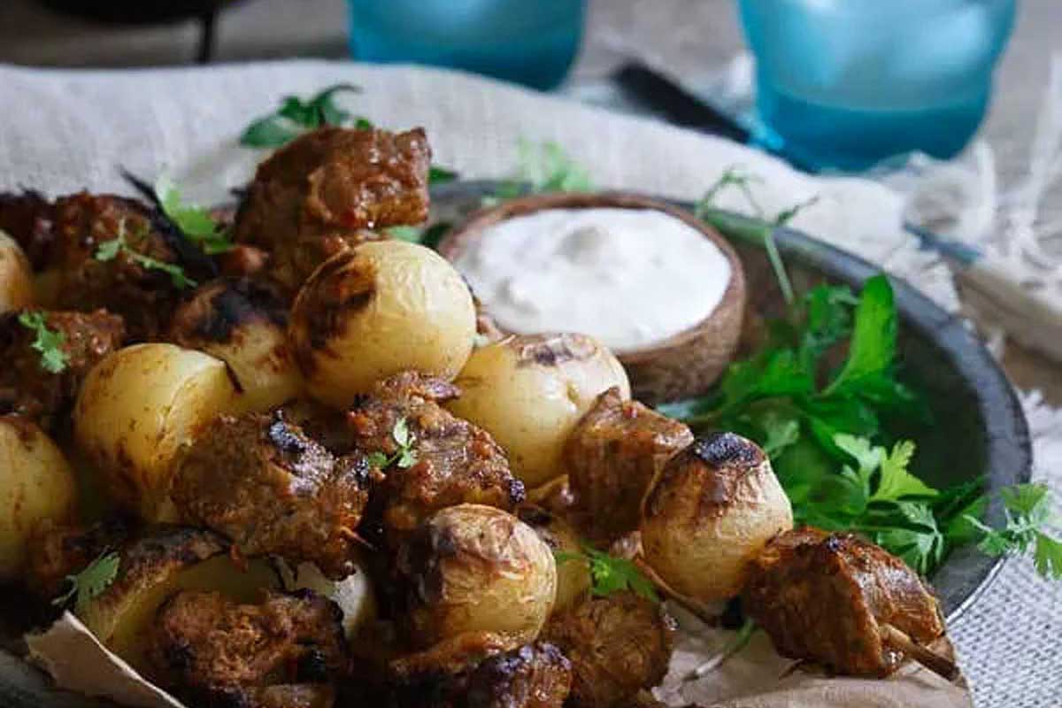 Skewers of meat with potatoes on a plate.