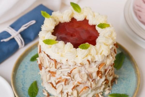 A cake topped with jam and whipped cream.