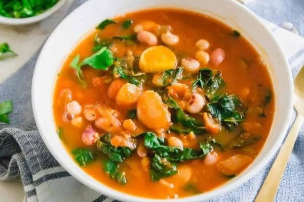 A bowl of white bean and kale soup.