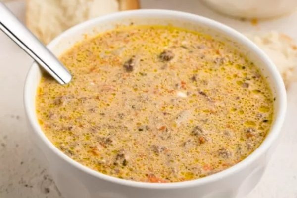 A creamy soup served with a side of fresh bread.