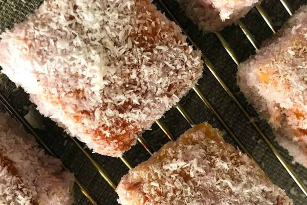A stack of donuts with powdered sugar on a cooling rack, perfect for indulging in delicious recipes.