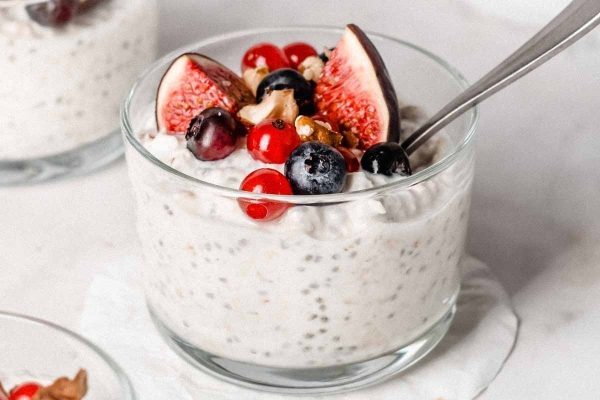 Chia pudding in a glass with berries and nuts.
