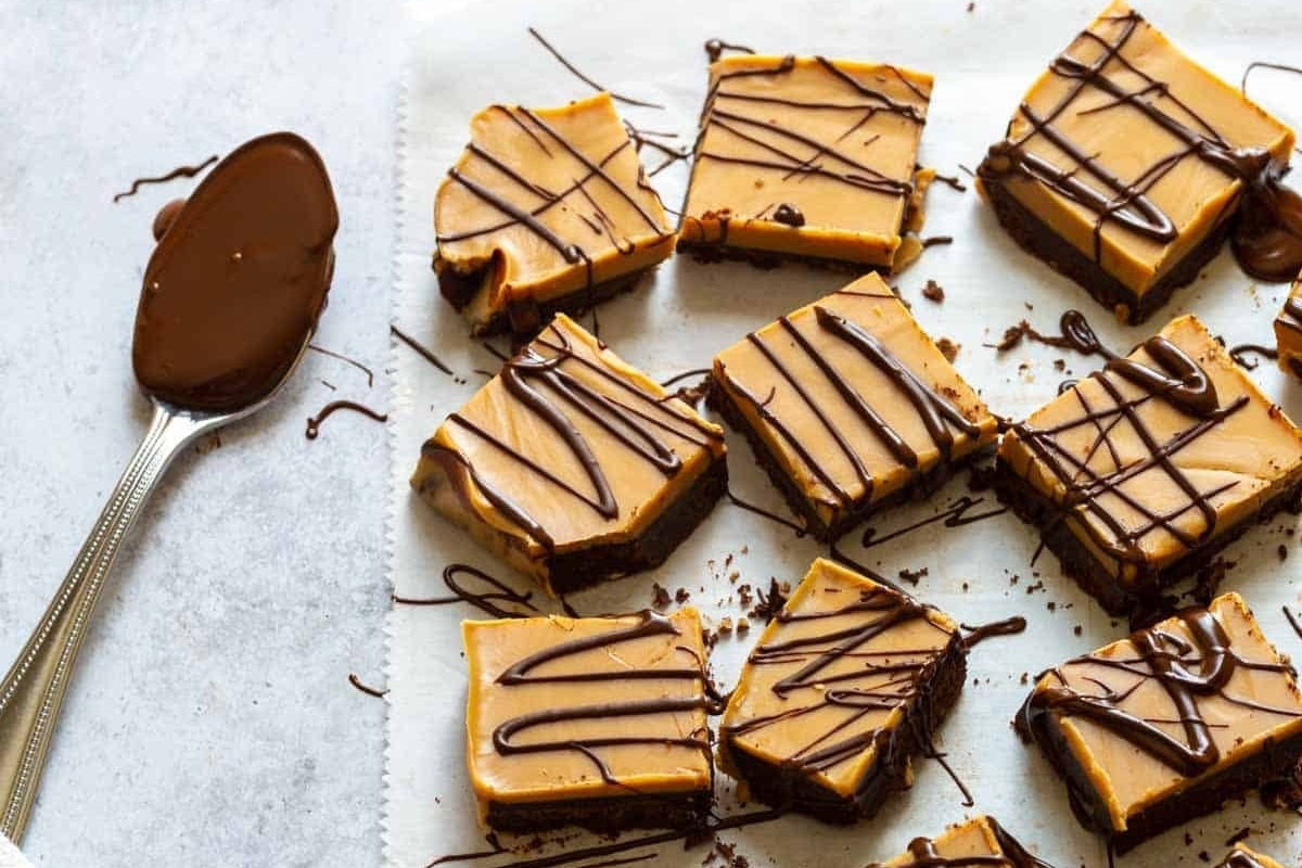 No Bake peanut butter fudge bars on a baking sheet with a spoon.