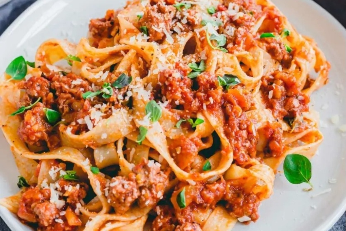 Italian Main Dish: Tagliatelle with meat sauce and parmesan cheese on a plate.
