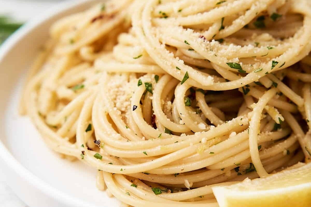 An Italian main dish featuring a plate of spaghetti with lemon and parsley.