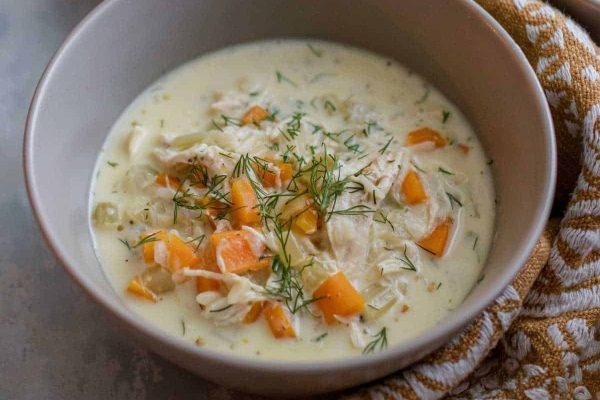 Chicken chowder in a bowl with carrots and dill.