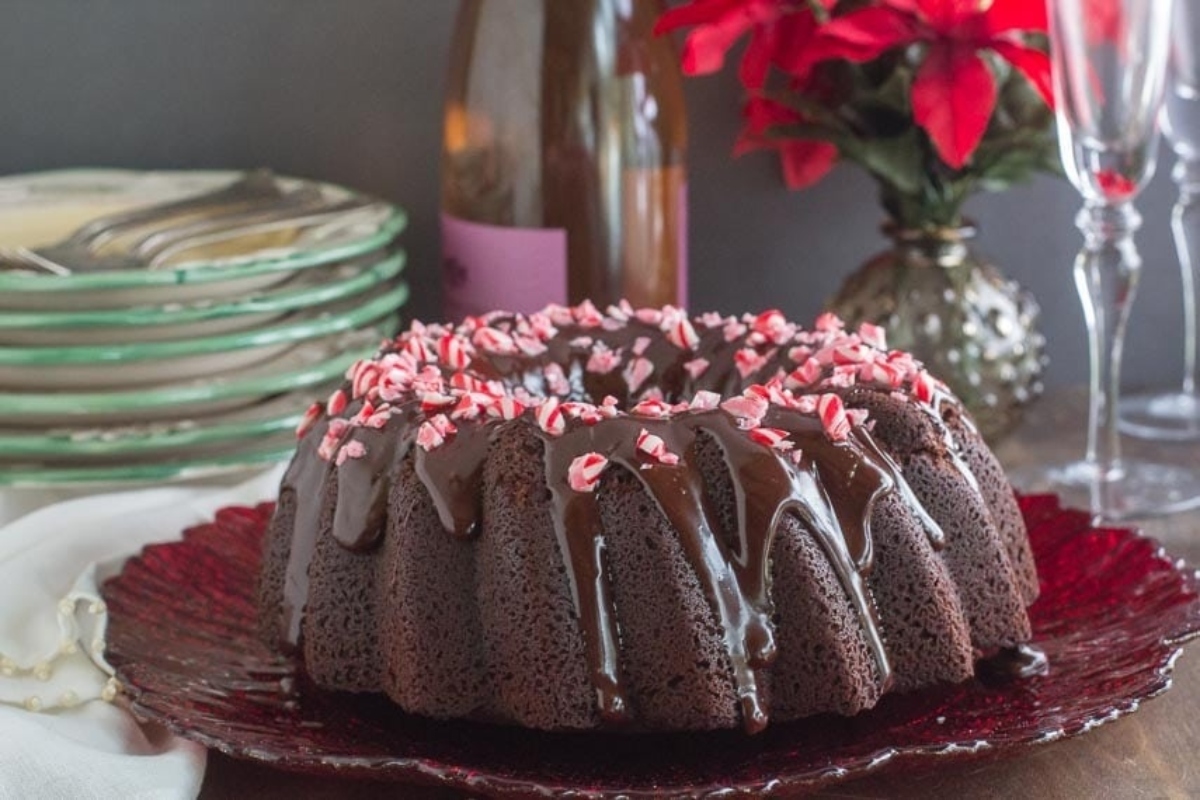 A chocolate bundt cake with peppermint icing on a plate.