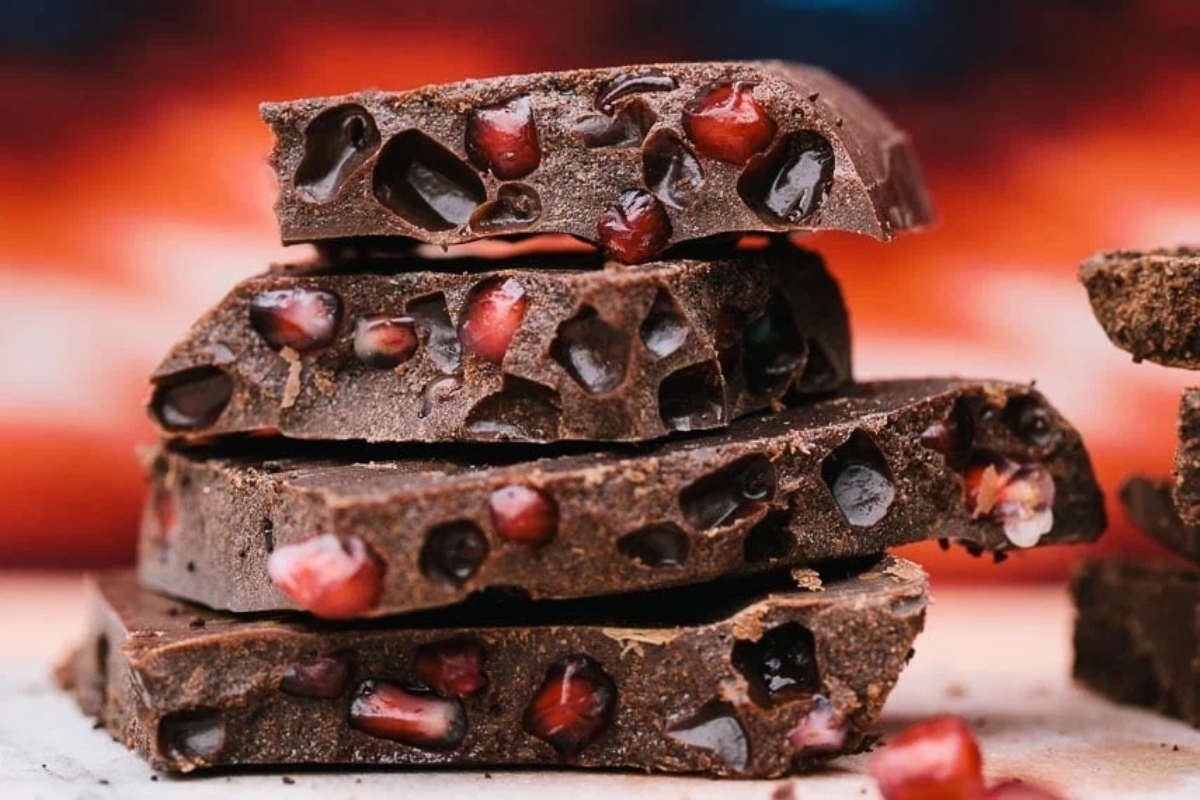 A stack of Christmas bark bars with pomegranate on top.
