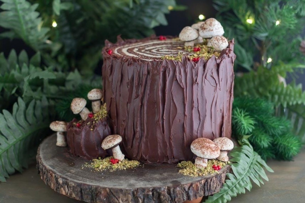 A Christmas cake decorated with mushrooms and greenery.