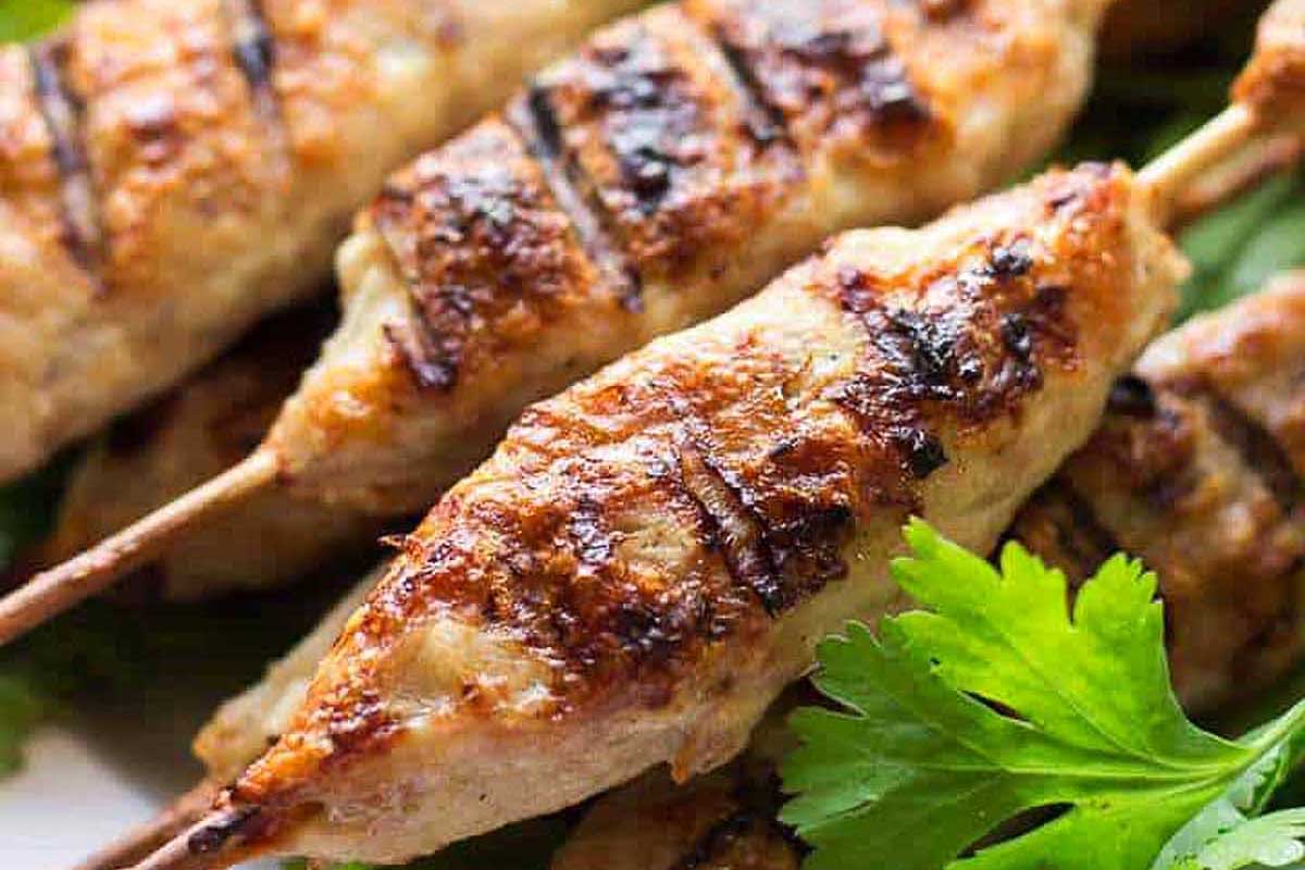 Grilled chicken kebabs on a plate with parsley.