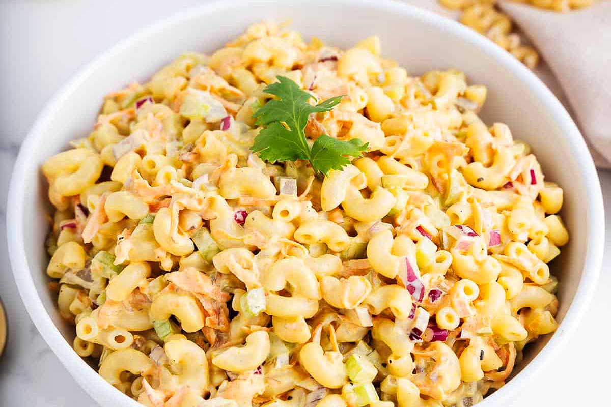 Pasta salad in a white bowl.