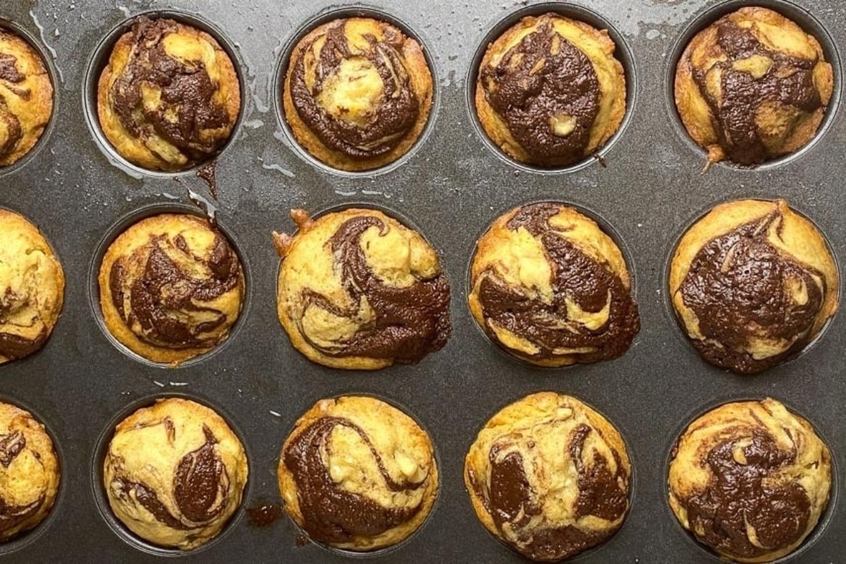 Nutella chocolate swirl muffins in a muffin tin.