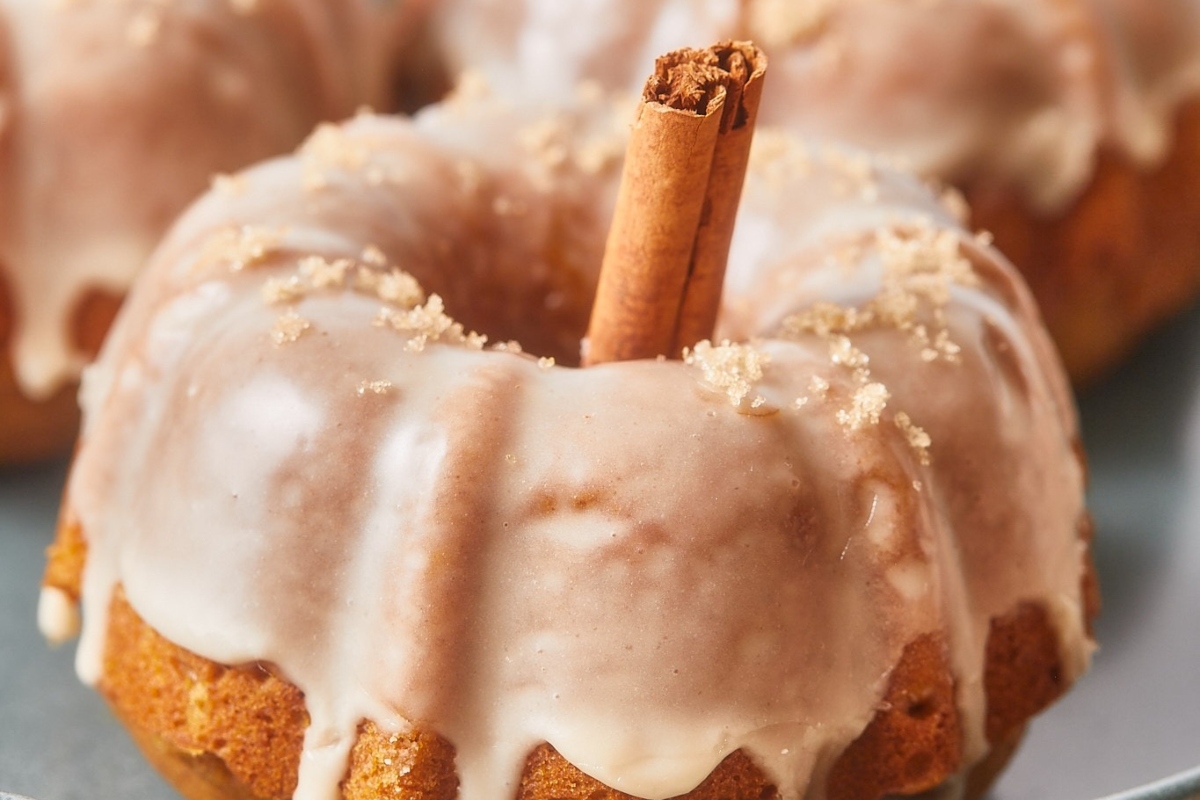 A cinnamon-laced Bundt cake adorned with sweet icing, displayed on a plate.