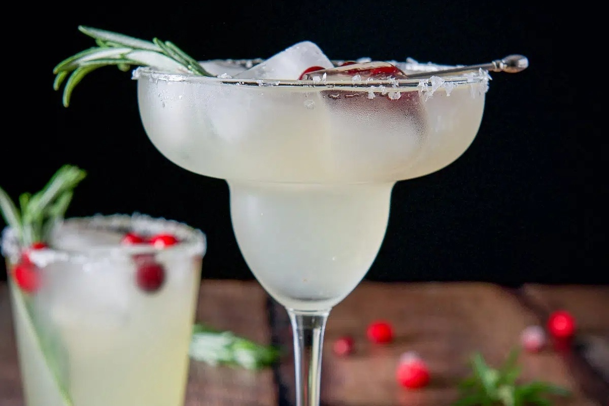 A festive Christmas margarita with tangy cranberries and fragrant sprigs of rosemary.