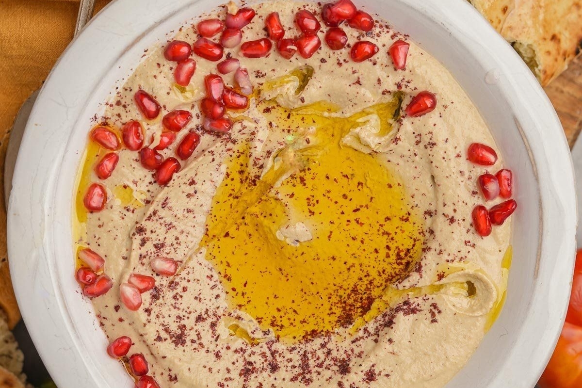 A flavorful pomegranate-infused hummus topped with pomegranate seeds. Perfect for your next potluck or family gathering!