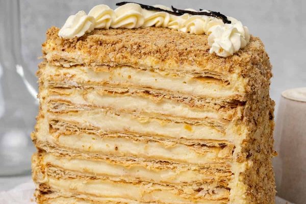 A layered cake with cream and icing on top.