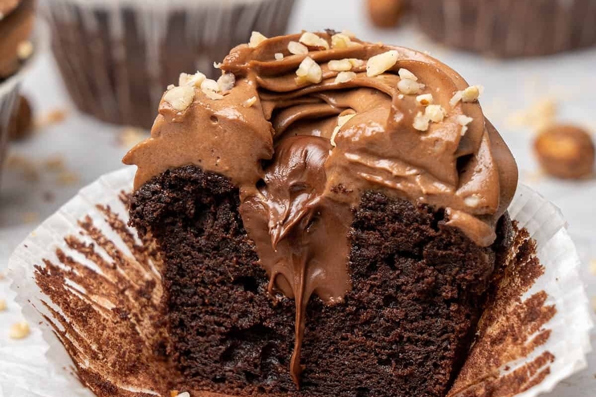 A Nutella-filled chocolate cupcake with a bite taken out of it.