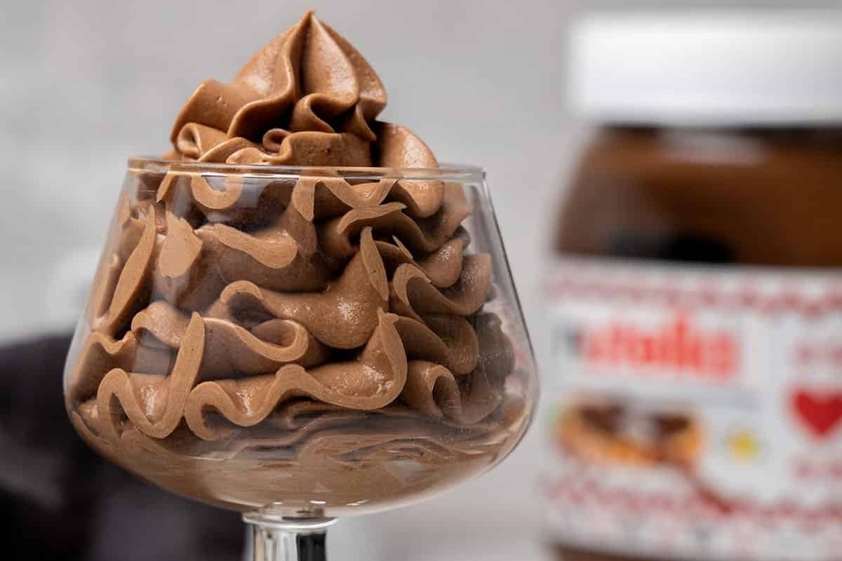 Indulge in a delightful Nutella mousse dessert topped with luscious whipped cream, perfect for those craving a taste of Nutella bliss.