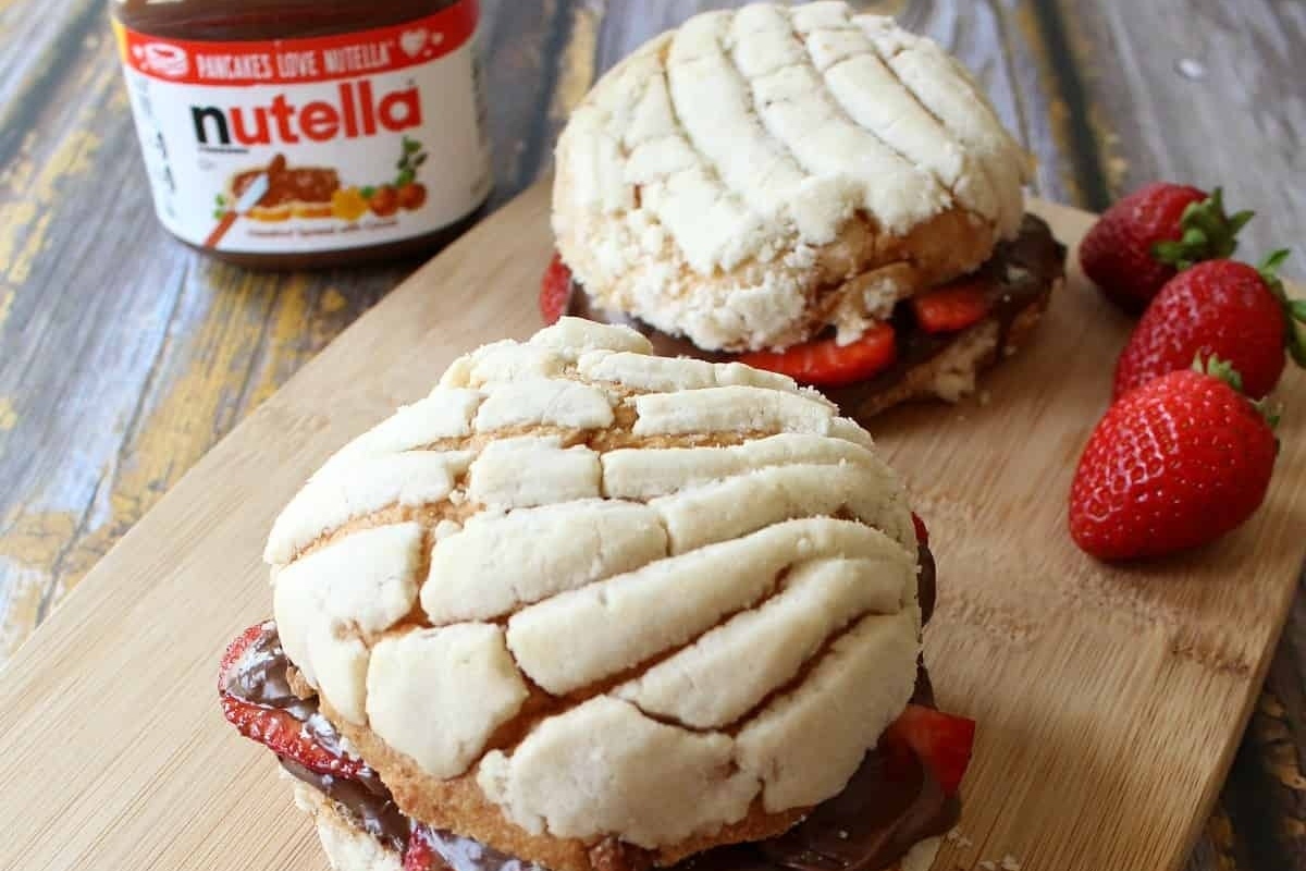 Delicious nutella and strawberry sandwiches beautifully arranged on a cutting board.