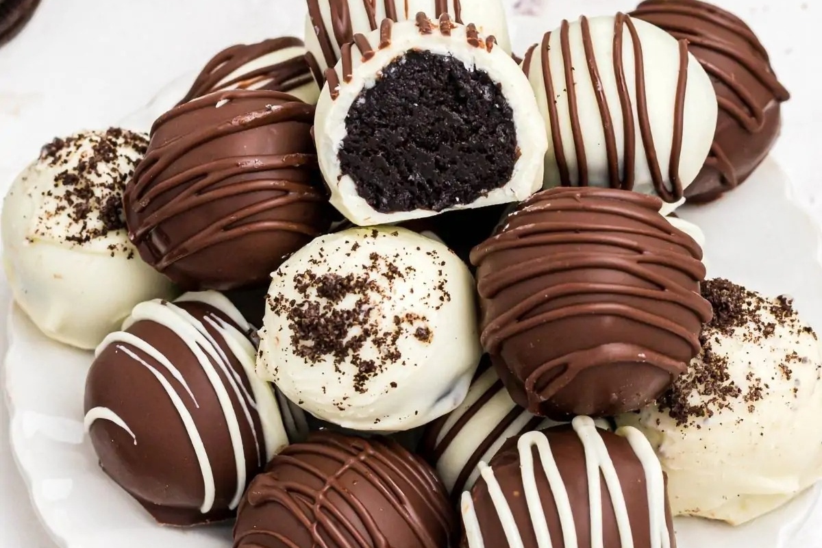 Chocolate covered oreo truffles on a white plate. This recipe offers a delicious twist on the classic oreo cookie by transforming it into a decadent truffle. Indulge in rich