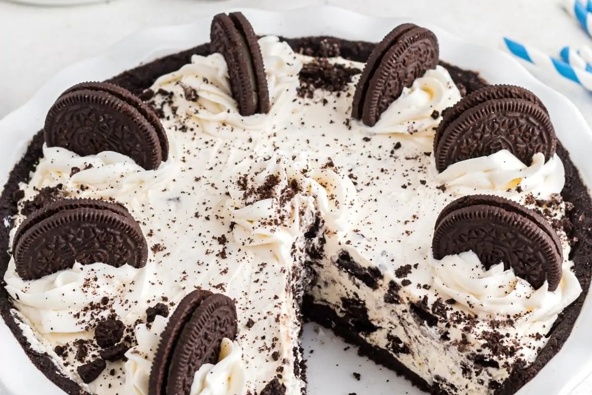 A delectable Oreo ice cream pie served on a festive white plate, perfect for holiday desserts. This no bake dessert combines the creamy goodness of Oreo ice cream with the ease of
