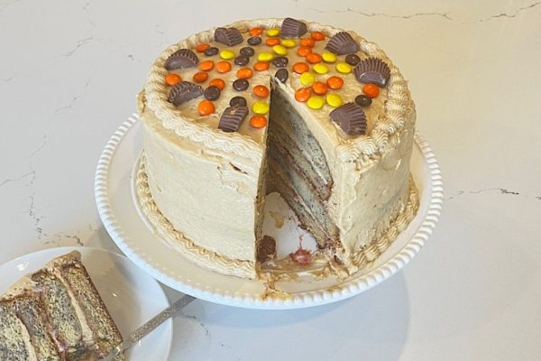 A peanut butter layer cake with a slice taken out.
