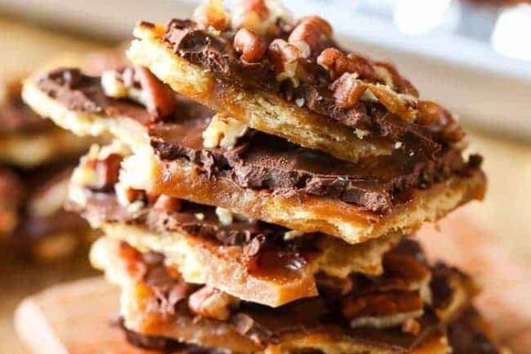 A stack of chocolate pecan taffy on a cutting board.