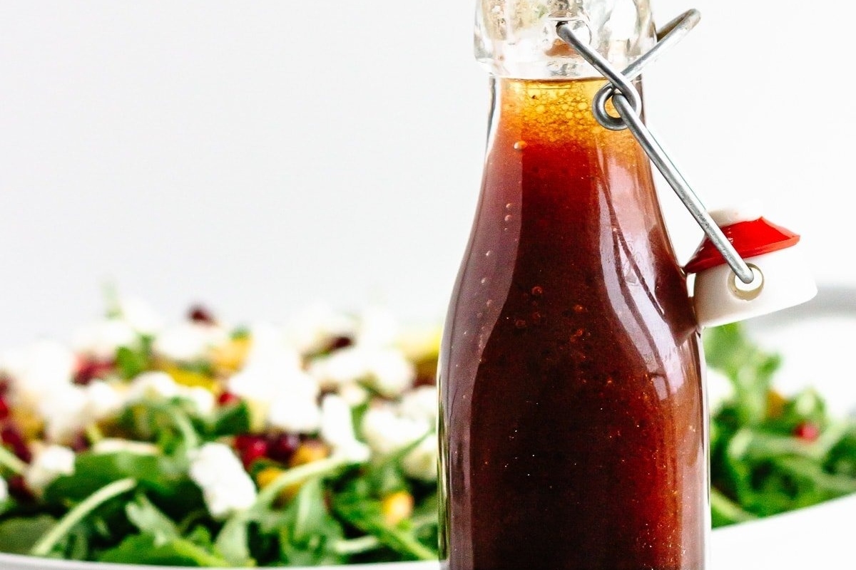 Recipes with Pomegranate to Add Color to the Season 9 A bottle of pomegranate balsamic vinaigrette next to a salad.