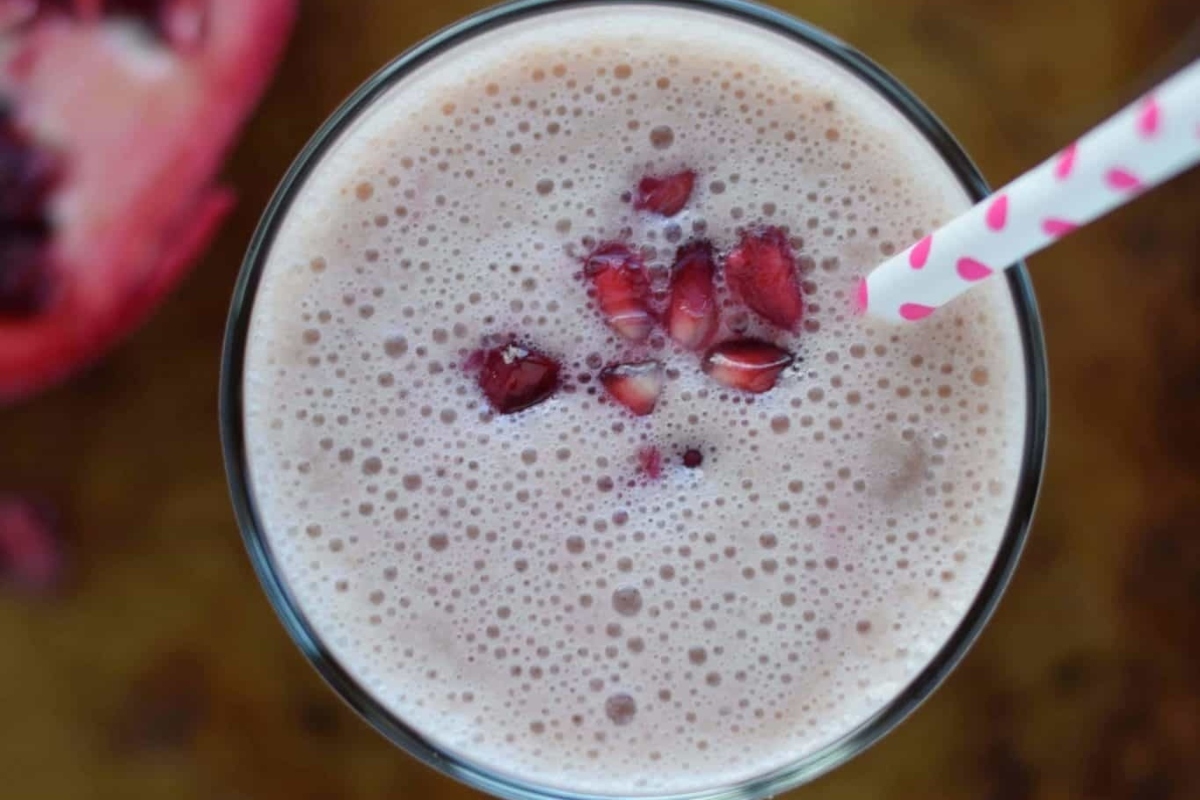 A refreshing pomegranate smoothie in a glass with a straw.