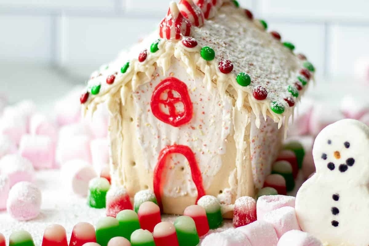A no bake gingerbread house decorated with candy canes and marshmallows, perfect for holiday desserts.