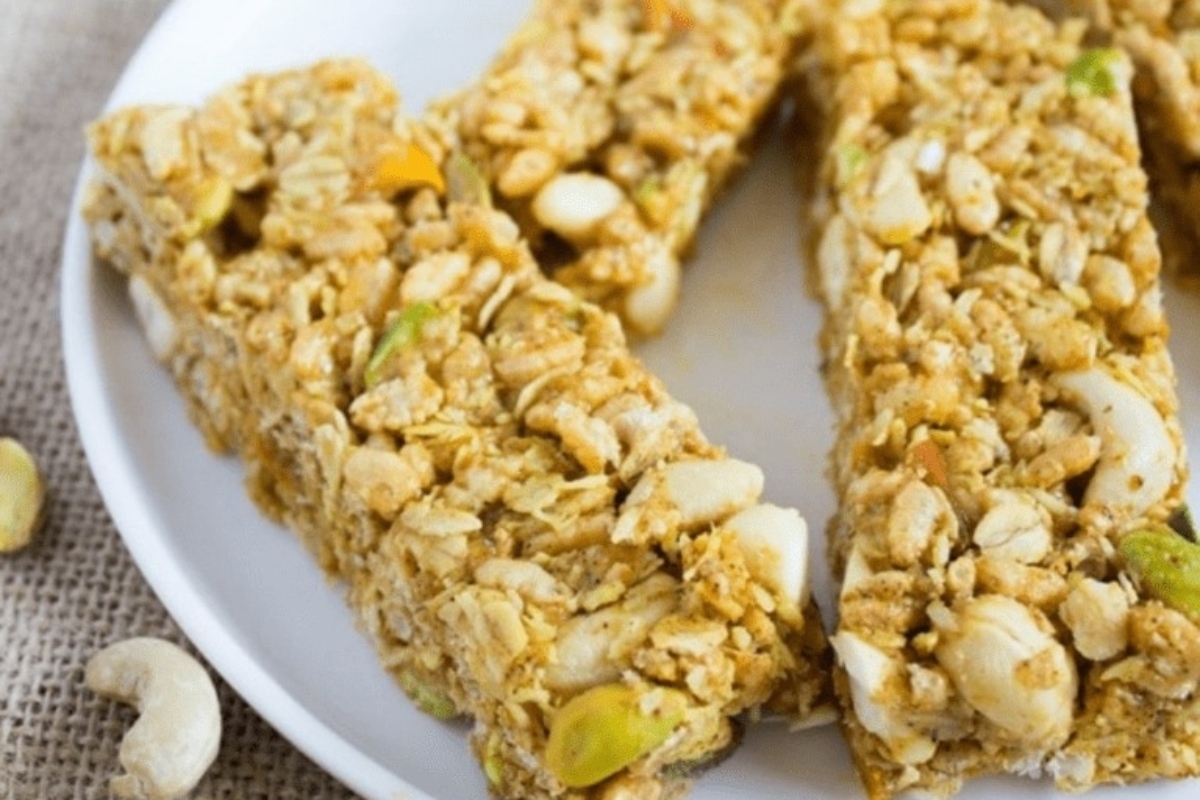 Granola bars with nuts and cashews sprinkled with pistachios on a plate.