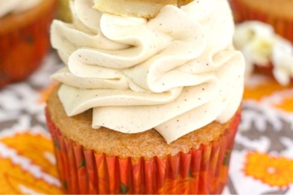 A cupcake with frosting and a banana on top.