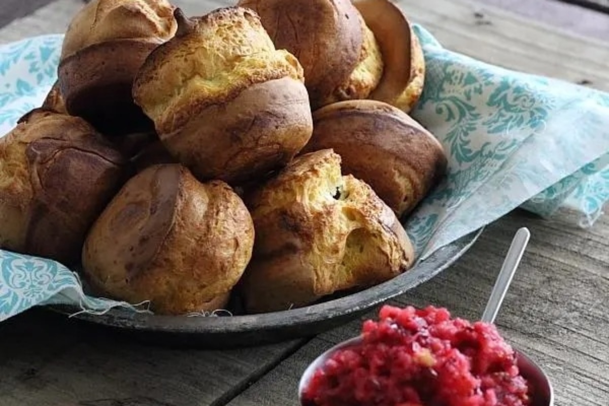 A basket of scones with cranberry sauce.